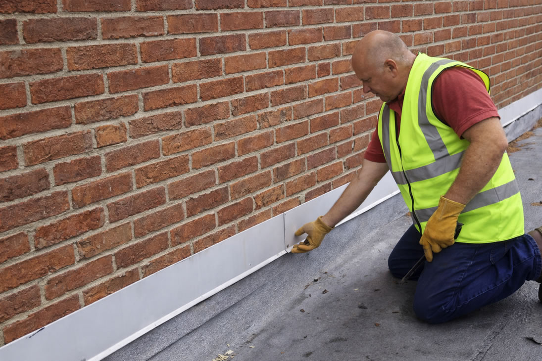 roofer checking garage roof flashing for leaks
